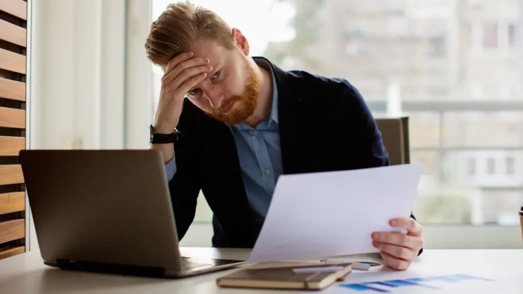 man overwhelmed at laptop
